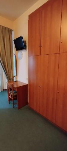 a room with a desk and a large wooden cabinet at Hotel Acerboli in Rimini