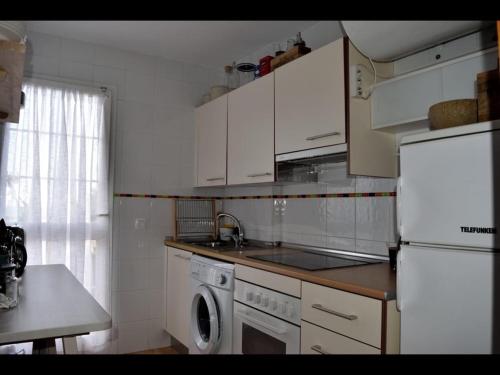 a kitchen with white cabinets and a sink and a dishwasher at Penthouse with fantastic sea view in Arroyo de la Miel