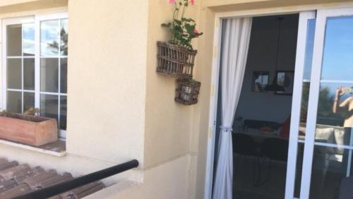 a plant in a basket on a wall next to a door at Penthouse with fantastic sea view in Arroyo de la Miel