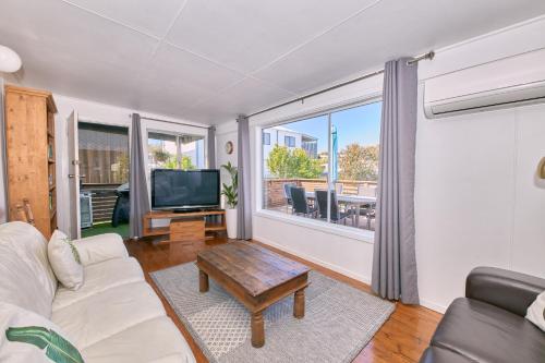 a living room with a couch and a tv at Bird Rock Shack 200m to beach and pet friendly in Torquay