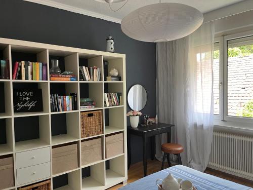 Una habitación con una estantería con una mesa y un espejo. en Ruhig trotz Stadtzentrum mit Parkplatz auf Privatgrundstück, en Hohenems