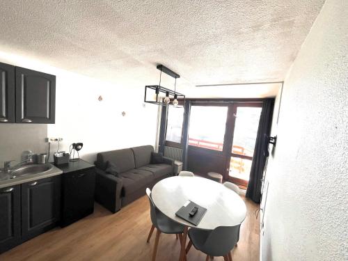 un soggiorno con un tavolo e un divano di Studios au pied des pistes , La Mongie Tourmalet, balcon plein Sud a La Mongie