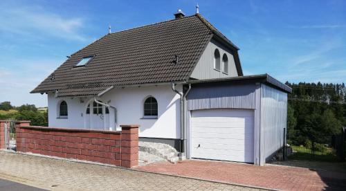 a small white church with a garage at Villa Lindenpark in Naila