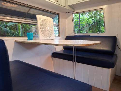 a table and chairs in a train with a fan at Vintage Coral Blue in Nelly Bay