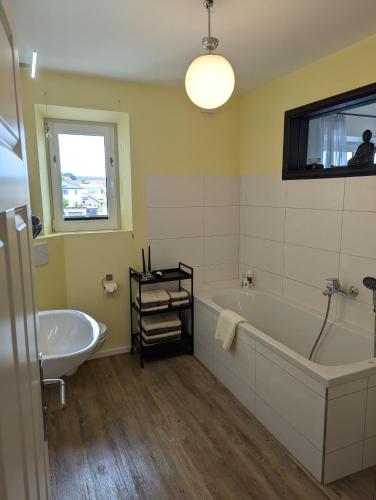 a bathroom with a tub and a sink at Haus Grünewald Unsleben in Unsleben