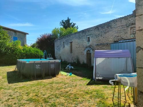 a yard with a tent and a hot tub at LE LOGIS DE LA PIERRE in Périgné