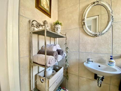 a bathroom with a shelf with towels and a sink at Oceanfront paradise - De Kelders in De Kelders