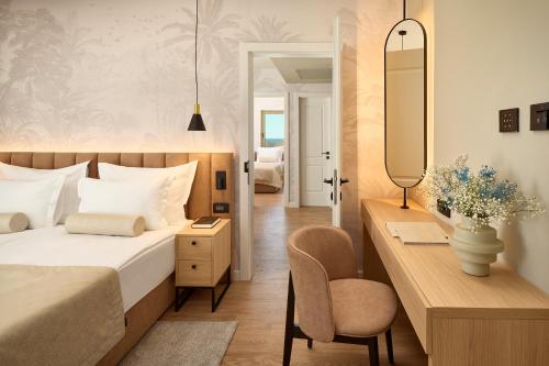 a bedroom with a bed and a desk with a chair at Hotel Moeesy, Blue & Green Oasis in Hvar