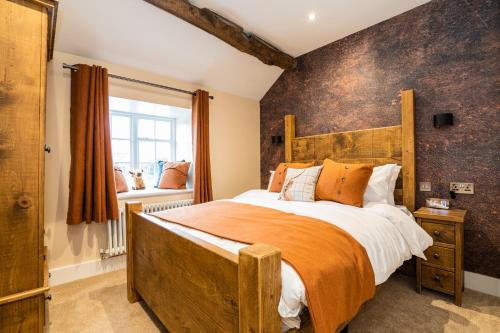 a bedroom with a large wooden bed and a window at Bulls Head - Holymoorside in Chesterfield