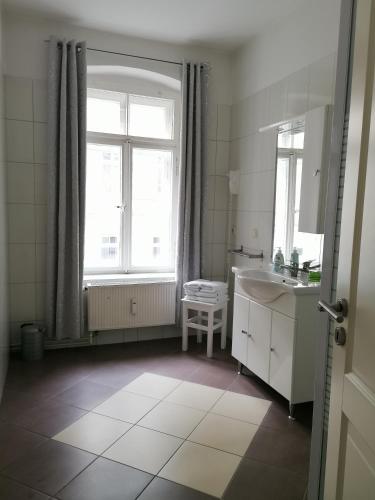 a white bathroom with a sink and a window at Pension Gina in Görlitz