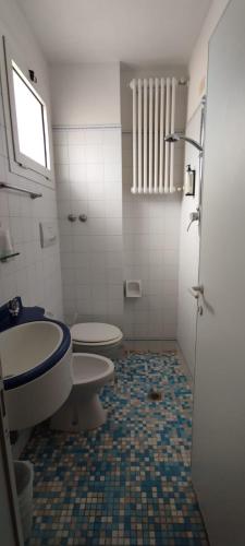 a bathroom with a toilet and a sink at Hotel Acerboli in Rimini