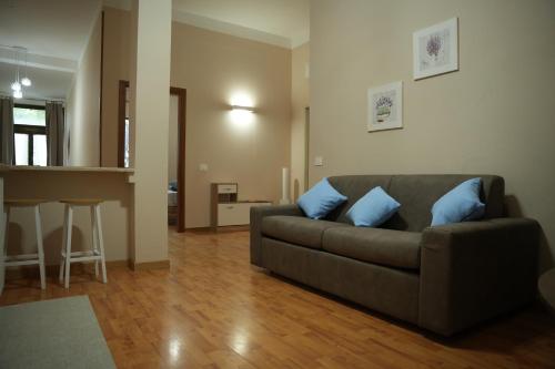 a living room with a couch with two blue pillows at Sergio apartments - Vaiano in Valiano