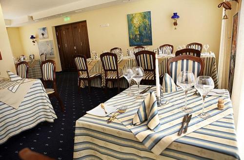 a dining room with tables and chairs with wine glasses at Birutes Uostas in Šventoji