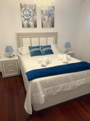a bedroom with a large white bed with blue pillows at Casa Parlera in Ribeira