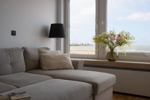a living room with a couch and a window at Suite Felice in Knokke-Heist