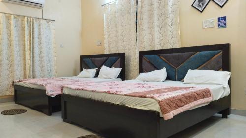 Giường trong phòng chung tại OM Palace Guest House-Fully Air Conditioned