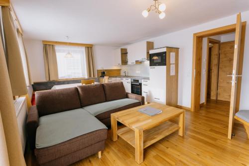 a living room with a couch and a table at Pension Bergbauernhof Irxner in Schladming