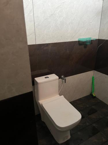 Un baño con un inodoro blanco en una cabina. en Akazumba home stay, en Auroville