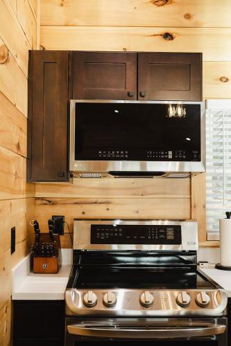 a kitchen with a stove and a microwave at Tri-Lake Escape in Naples