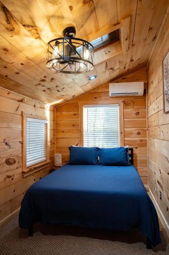 a bedroom with a blue bed in a cabin at Tri-Lake Escape in Naples