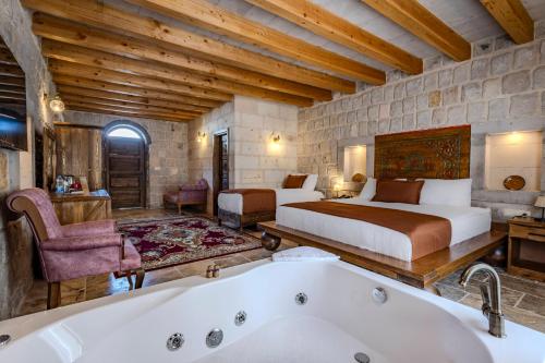 a bedroom with two beds and a bath tub at Gala Cave Cappadocia in Goreme