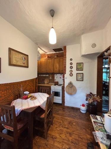a kitchen with a table and a kitchen with a table and chairs at Етно кућа Нана Добра in Dimitrovgrad