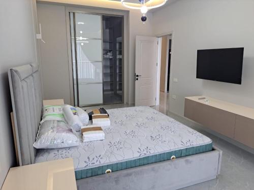 a bedroom with a bed with a tv and a bed sidx sidx sidx at Sea Breeze in Nardaran
