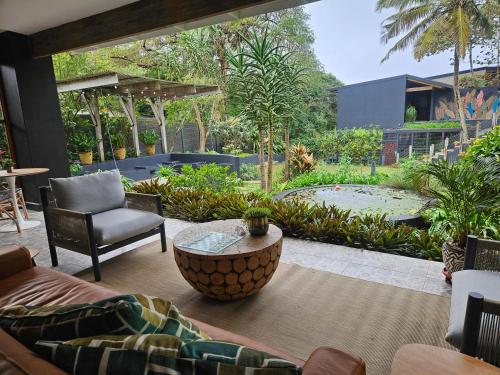 a patio with a couch and a chair and a table at Amoya Villa in St Lucia