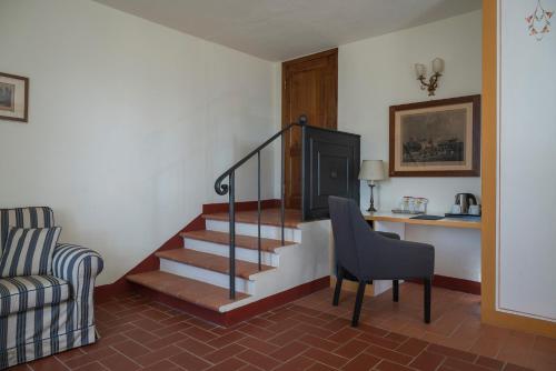 a living room with a staircase and a chair at Relais Vignale & Spa in Radda in Chianti