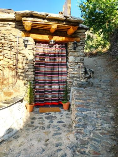a stone building with a door with plants in it at El Carpintero in Trevélez