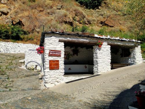 a small stone building with a sign on it at El Carpintero in Trevélez