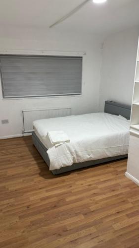 ボアハムウッドにあるPeeams Abode Borehamwoodのベッドと木の床のある寝室