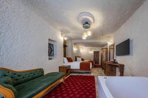 a living room with a tub and a bedroom at Gala Cave Cappadocia in Goreme