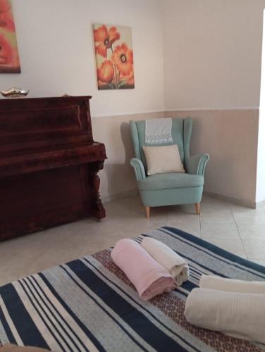 a room with a piano and a chair and towels at The Vesuvian House in San Giorgio a Cremano