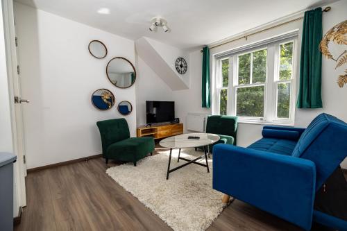 a living room with blue chairs and a table at Modern 2-Bed Apartment - Near Train and Town - Parking Available in High Wycombe