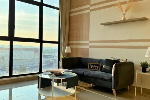 a living room with a couch and a table at Sunset View Stay at Conezion IOI in Gua Sai