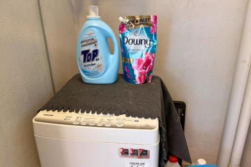 a bottle of laundry detergent sitting on top of a washing machine at Sunset View Stay at Conezion IOI in Gua Sai