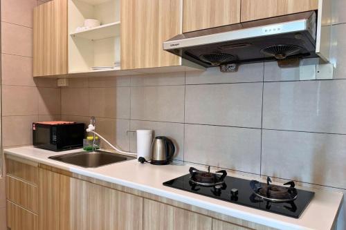 a kitchen with a stove and a sink at Sunset View Stay at Conezion IOI in Gua Sai