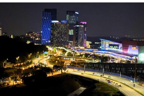 a city at night with a bridge and buildings at Sunset View Stay at Conezion IOI in Gua Sai