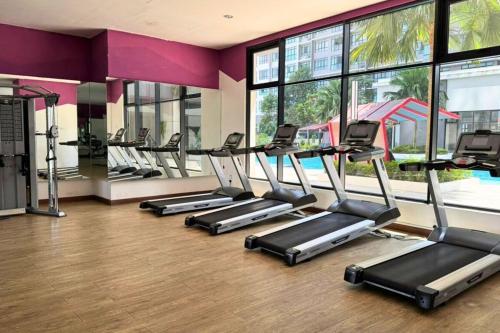 a row of treadmills in a gym with windows at Sunset View Stay at Conezion IOI in Gua Sai