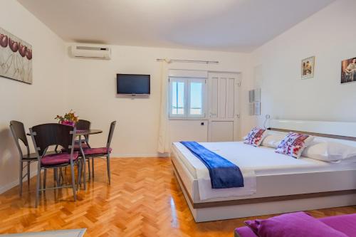 a bedroom with a bed and a table and chairs at Apartment Bonaca in Posedarje
