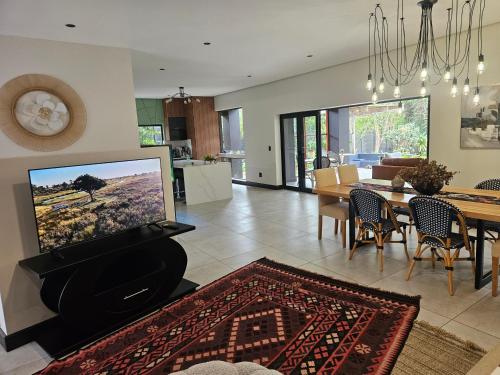 a living room with a television and a dining room at Amoya Villa in St Lucia