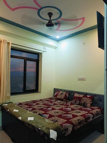 a bedroom with a bed and a ceiling with a fan at Hotel vijay in Palāi