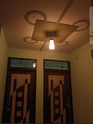two doors in a room with a ceiling fan at Hotel vijay in Palāi