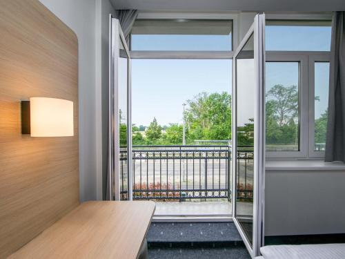 a room with a view of a balcony at B&B HOTEL Berlin-Adlershof in Berlin