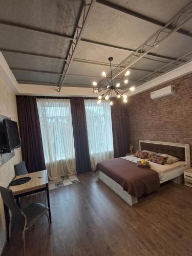 a bedroom with a bed and a desk and a television at Apartment on Sumskaya 46 "Central Residence" in Kharkiv