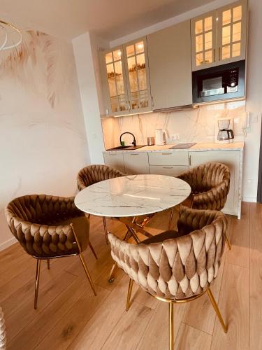 a kitchen with two tables and chairs in a room at Sunrise Euronia in Międzyzdroje