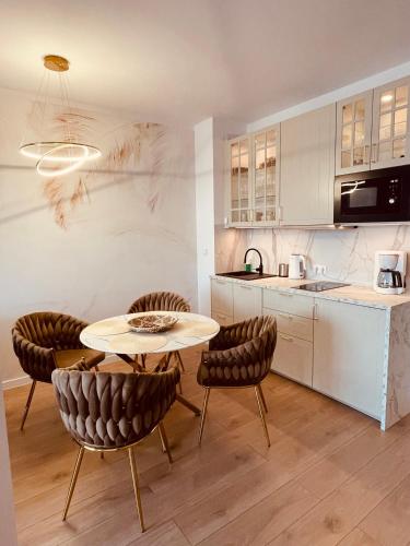 a kitchen with a table and chairs in a room at Sunrise Euronia in Międzyzdroje