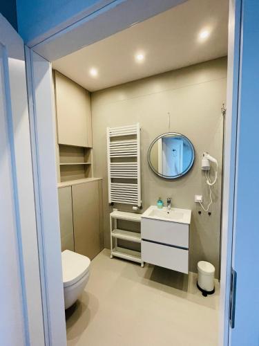 a bathroom with a toilet and a mirror at Sunrise Euronia in Międzyzdroje