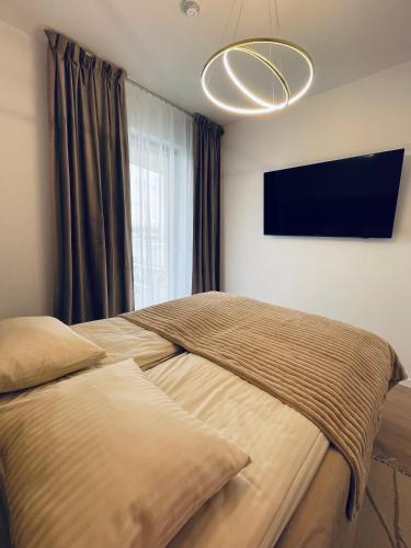 a bedroom with two beds and a flat screen tv at Sunrise Euronia in Międzyzdroje